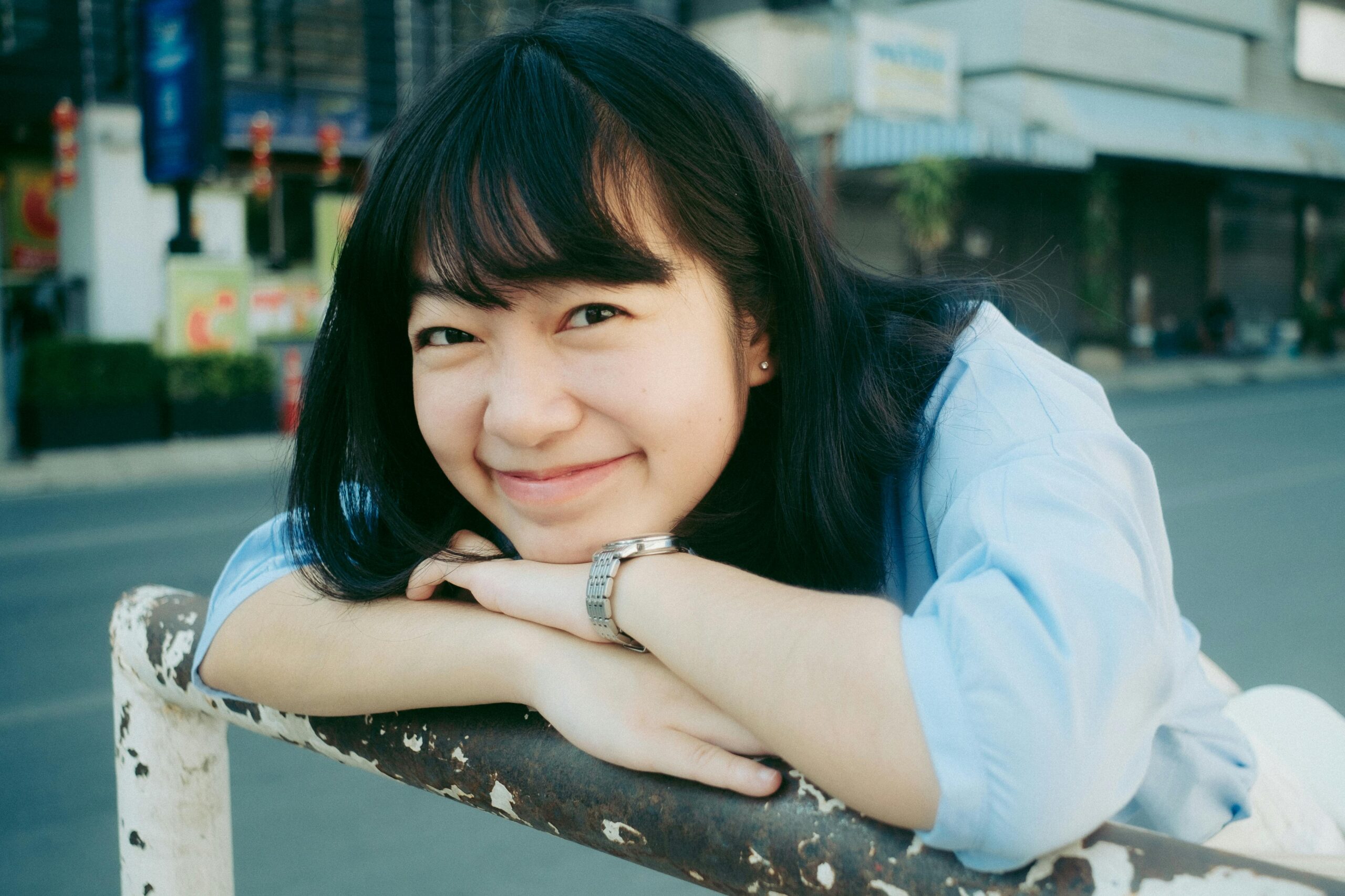 Cheerful young woman smiling outdoors in Chiang Mai, Thailand. Bright and joyful portrait.